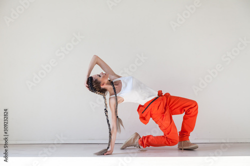 Portrait of a beautiful fashionable woman with braids dancing to the music of youth photo