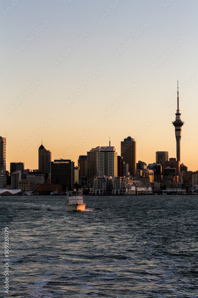 Auckland Sunset from sea vertical with boat.