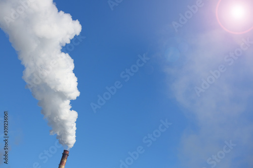 White smoke comes from pipes against blue sky