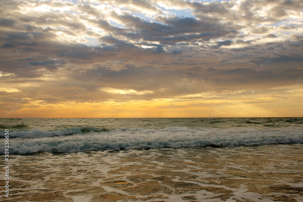 Naklejka premium Beautiful sunset on the beach. The surf pounds the shore. Phuket, Thailand