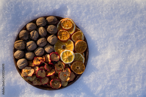 winter flat lay with dry orange and apple , walnut on copper tray in garden