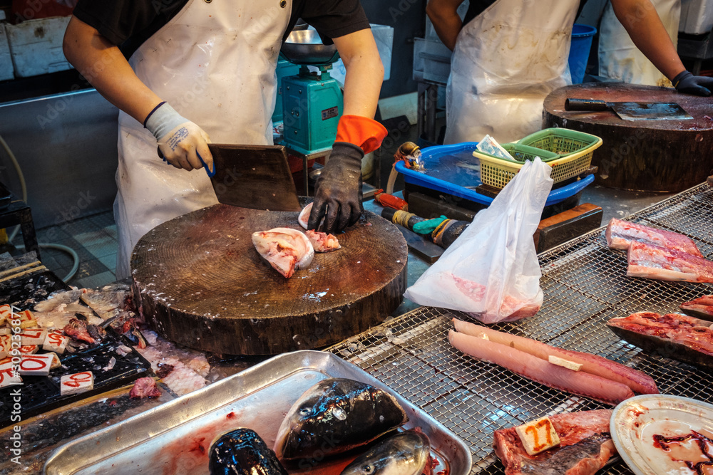  Vendor cuts fish on food market in HongKong, China