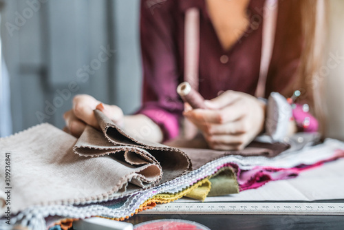 Close up of woman designer choosing fabric color for new collection
