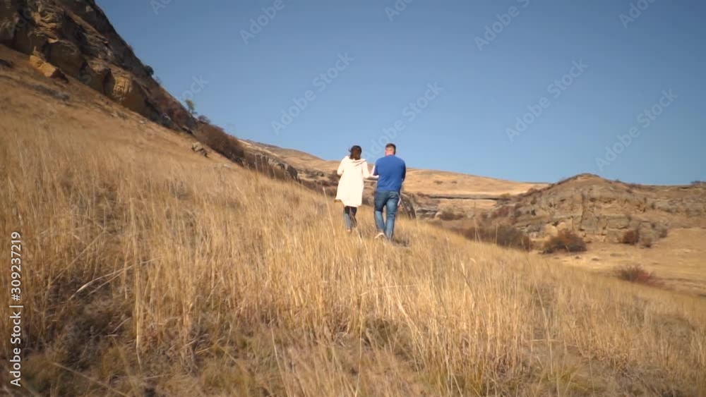 young family walks through the autumn field young family walks through the autumn field