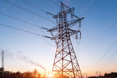 High-voltage power lines at sunset or sunrise. High voltage electric transmission tower