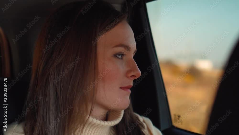 young girl rides in a car and looks out the window young girl rides in a car and looks out the window