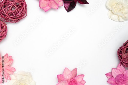 weiße rosa Blüten und Holzgeflechtkugeln am Rand mit Freiraum für Text in der Mitte © Kerstin