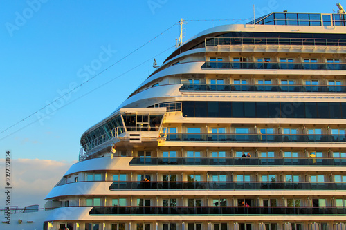 Close up view of nose huge luxury cruise ship glides out of the port of Koper during magic sunrise. Colorful vibrant sky. Travel and tourism concept. Koper, Slovenia
