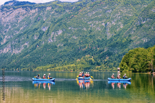 Scenery with people canoeing on Bohinj Lake in Slovenia