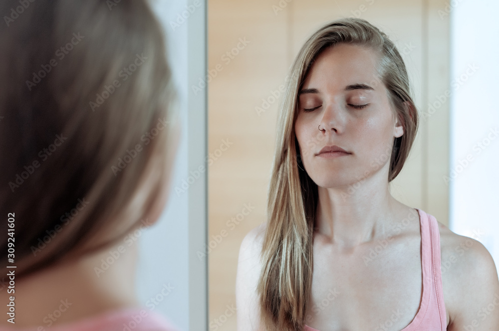 Young blond girl photographed in front of the mirror Young blond girl photographed in front of the mirror