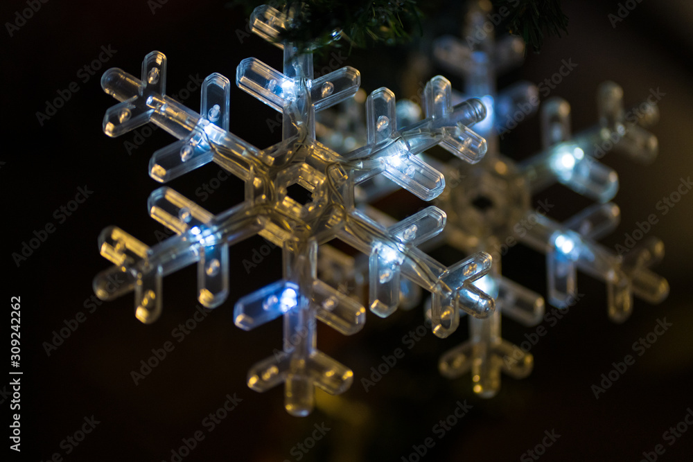 Hängende LED Schneeflocke aus Plastik an der Tanne Hängende LED Schneeflocke aus Plastik an der Tanne