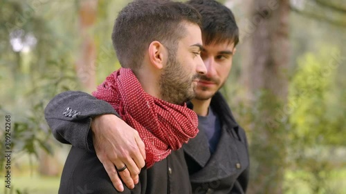 young attractive gay conforting his boyfriend embracing him photo