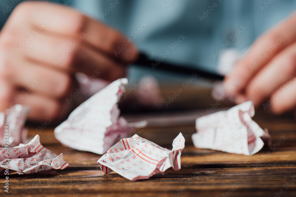 Φωτογραφία cropped view of gambler holding pen near crumpled lottery tickets
