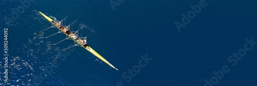 Foto Aerial drone ultra wide photo of team of fit women practising in sport canoe in