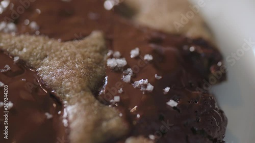 Sprinkle sea salt onto chocolate cookie close up