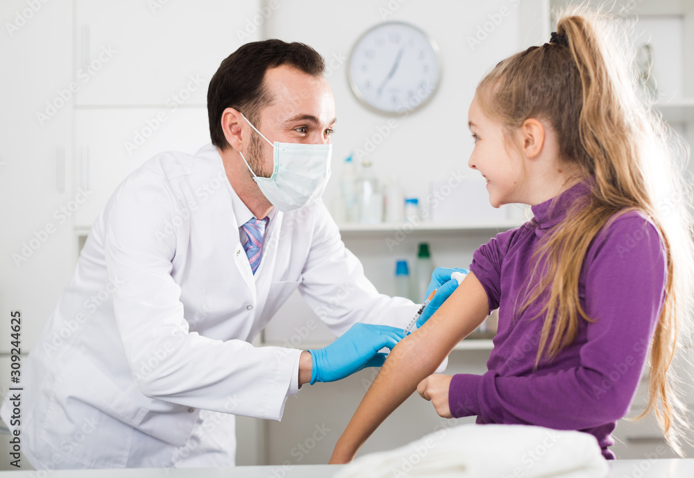 Fototapeta premium Male doctor injecting little patient