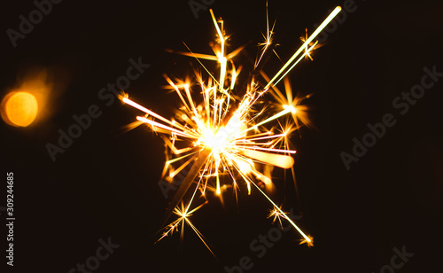 Sparklers for Christmas and New Year close-up on a holiday background in warm colors