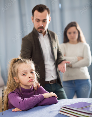 Young parents lecturing girl for bad behavior