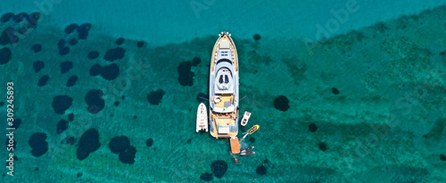 Aerial drone ultra wide photo of luxury yacht docked in tropical exotic island with turquoise sea © aerial-drone