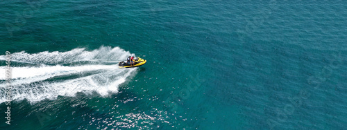 Aerial photo of jet ski with couple cruising in high speed in Caribbean tropical crystal clear waters