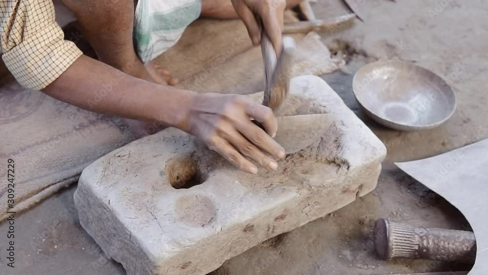 Potter shaping metal dish with hammer and stone mold. Process of making handcrafted metal utensil Potter shaping metal dish with hammer and stone mold. Process of making handcrafted metal utensil
