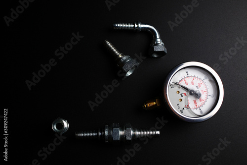 gauge and hydraulic fittings on a black background