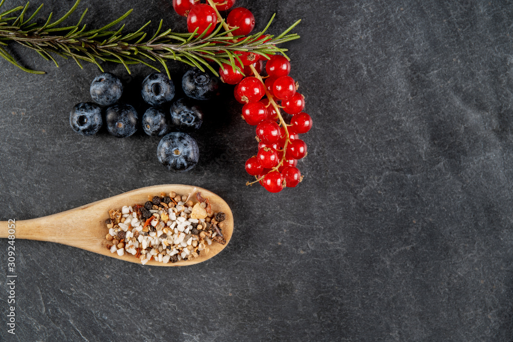 Fototapeta premium verschiedene zutaten wie blaubeeren, rosmarin und johannisbeeren auf einer schiefertafel 