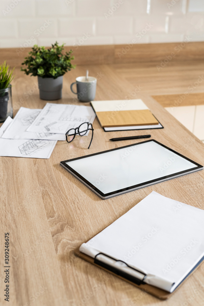 Clipboard, tablet and plan on wooden kitchen counter Clipboard, tablet and plan on wooden kitchen counter