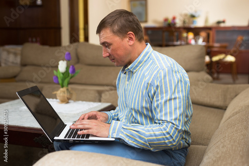 Man using laptop during filling out papers