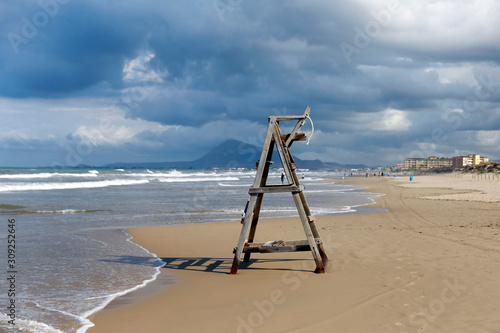 Old lifeguard tower at the abandoned beach. Big sand beach in Spain. 