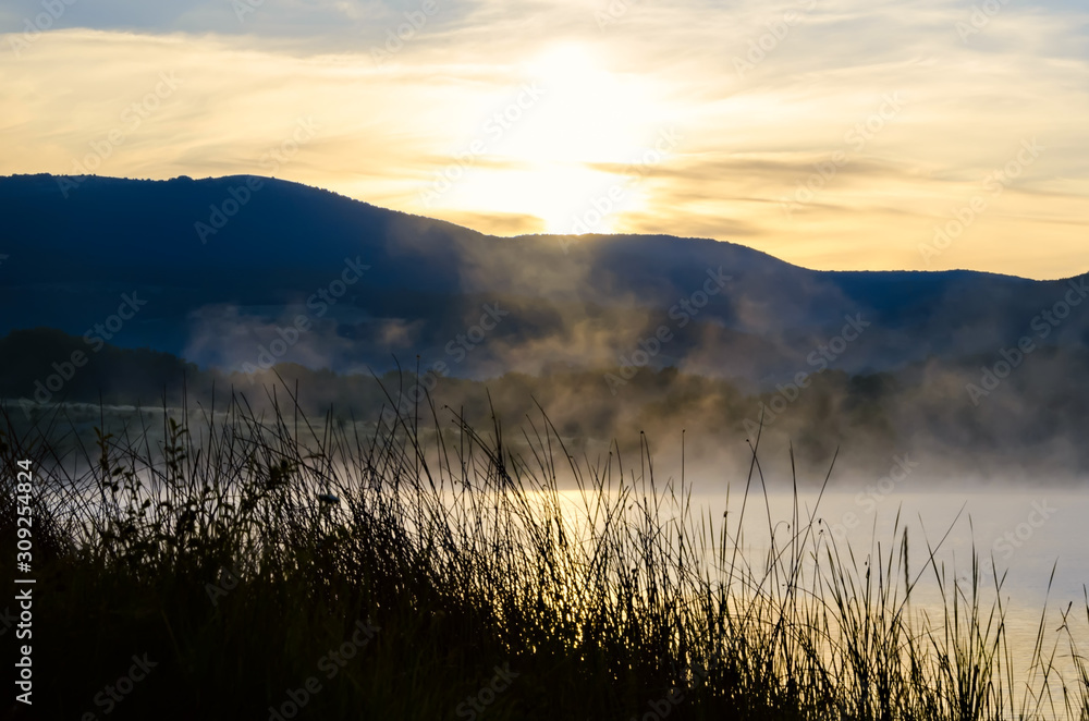 Early morning fog over the lake or river. Sunrise landscape.