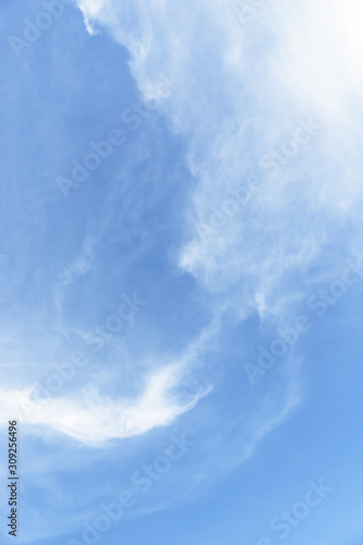 Light blue sky with cirrocumulus clouds. Beautiful sky background, vertical orientation