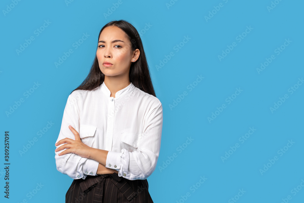 Freestyle. Young woman wearing shirt and skirt standing isolated on blue crossed arms mistrustful copy space Freestyle. Young woman wearing shirt and skirt standing isolated on blue crossed arms mistrustful copy space