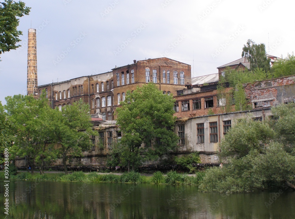 The building of an old factory near a lake with trees in Kaliningrad.
