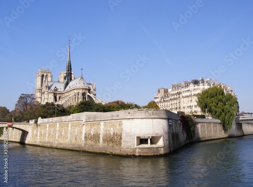 View of the promenade, Notre Dame Cathedral and beautiful houses with a pleasure boat on a clear autumn day.