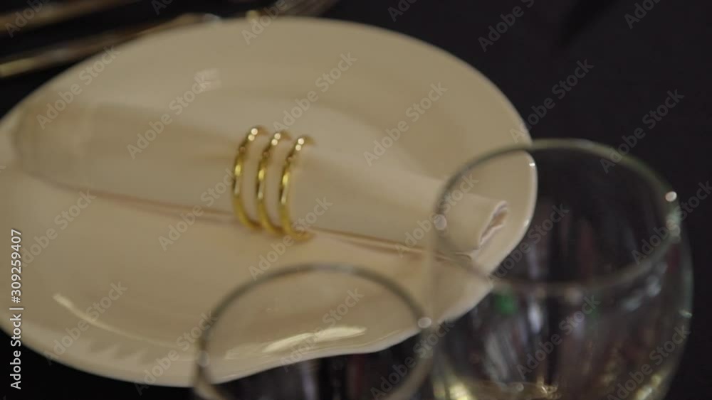 Elegant wedding table with glass and plate for banquet in restaurant interior. Beautiful desk with decoration and crockery is ready for celebration in hall. Concept: business, luxury, catering service Elegant wedding table with glass and plate for banquet in restaurant interior. Beautiful desk with decoration and crockery is ready for celebration in hall. Concept: business, luxury, catering service