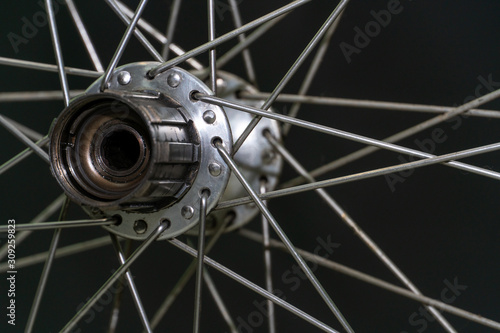  Bicycle repair. Cleaning and replacement of grease in the rear hub of the bike. The rear wheel of the bike on a black background. Spokes and hubs are gray. Modern workshop. Freehub close up