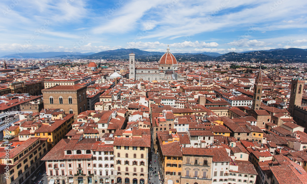 Obraz premium Beautiful super wide-angle aerial view of Florence, Italy with Florence Cathedral di Santa Maria del Fiore, mountains, skyline and scenery beyond the city, seen from the tower of Palazzo Vecchio