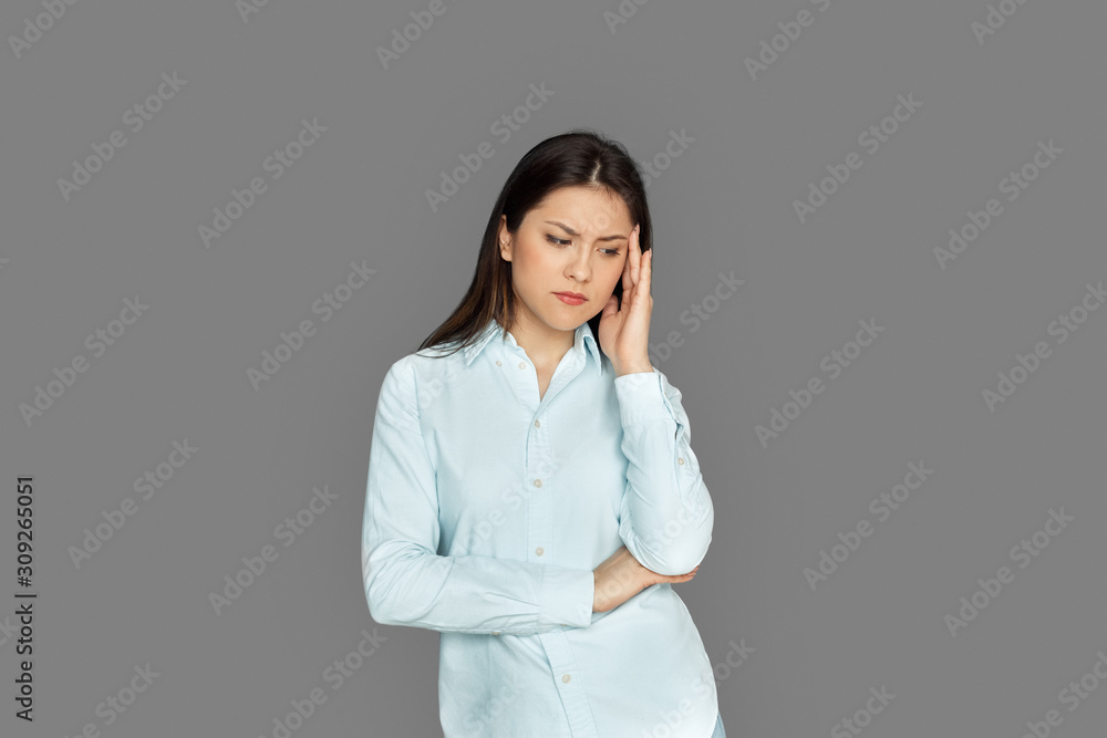 Freestyle. Young woman standing isolated on grey holding head stressed Freestyle. Young woman standing isolated on grey holding head stressed