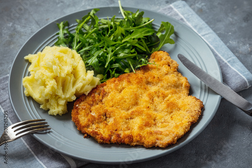 Chop pork cutlets , served with mashed potatoes and arugula. 