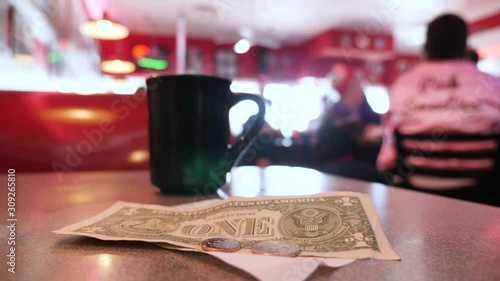 Tips, check and cup of coffee on the table of American diner