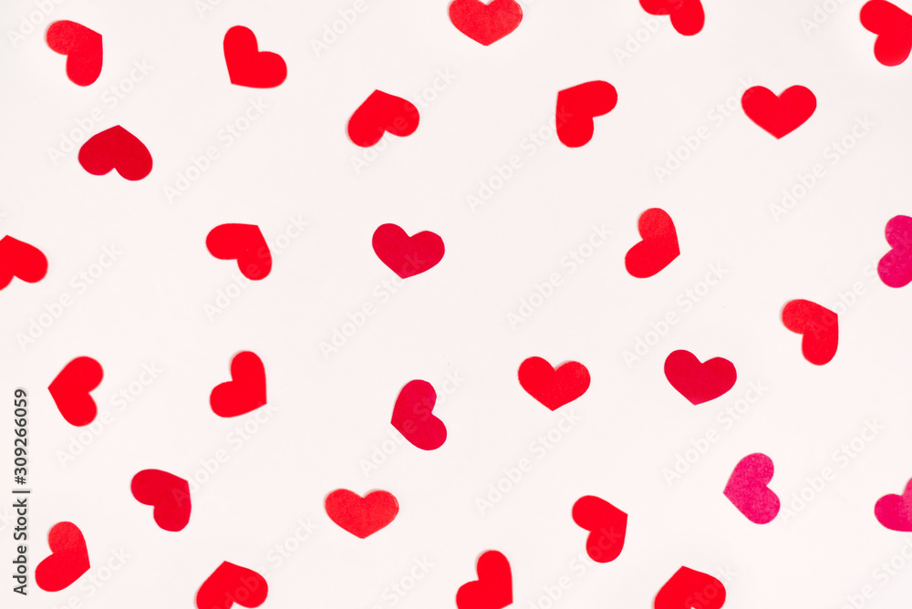 Red hearts are scattered in a chaotic order on a white background. Valentine's day holiday card
