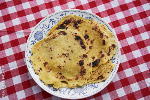 Top view on the traditional simple pancakes made from potatoes and dry fried in steel pan and served on the rustic folk plate. Old and delicious side dish in Czech and Slovakian cuisine called lokse.