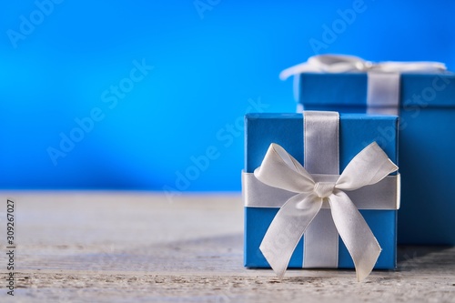 Blue gift box on white wooden table.