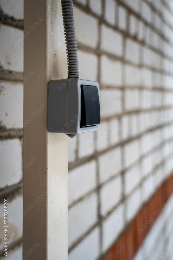 Outdoor light electic switch on iron stand and birck wall Outdoor light electic switch on iron stand and birck wall
