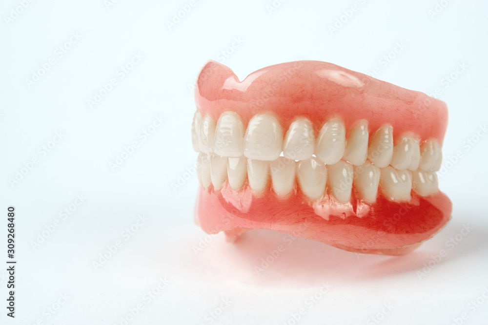 Diagnosis prosthetics treatment concept. Artificial teeth and magnifying glass Diagnosis prosthetics treatment concept. Artificial teeth and magnifying glass