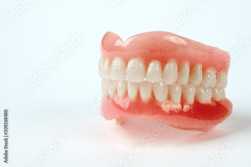 Diagnosis prosthetics treatment concept. Artificial teeth and magnifying glass