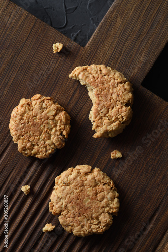 Home baking. Healthy oatmeal cookies on dark oak cutting board
