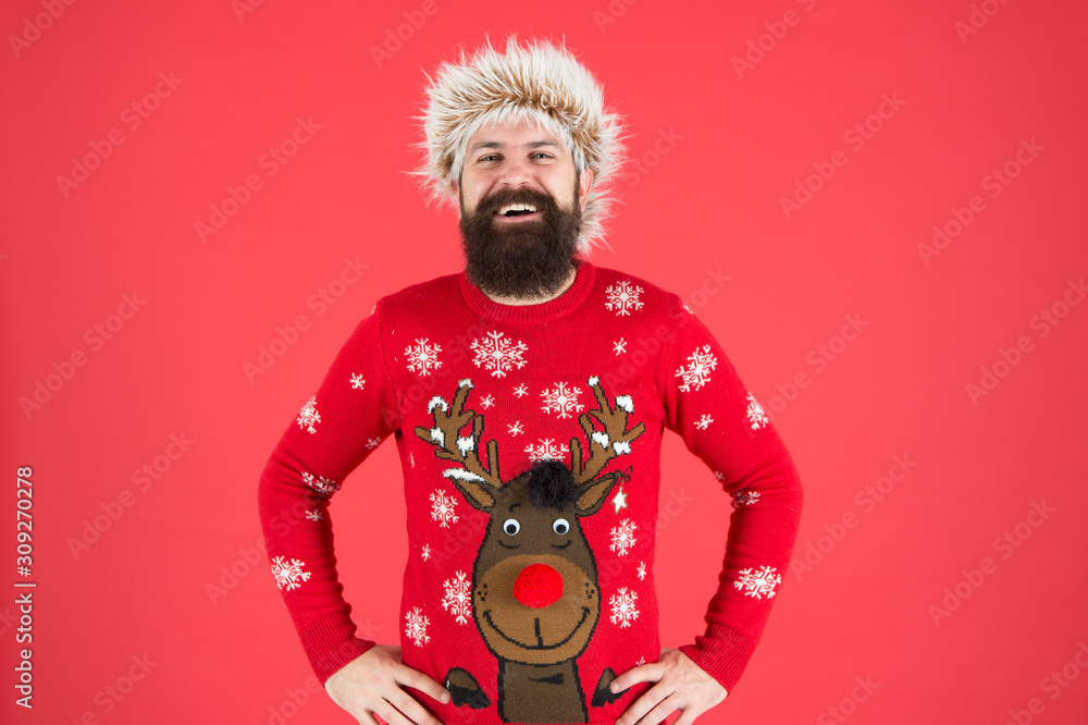 Bright memories. happy new 2020 year. bearded man on red background. funny man with beard in knitted sweater. smiling hipster in earflap hat. winter holiday activity. warm clothes in cold weather