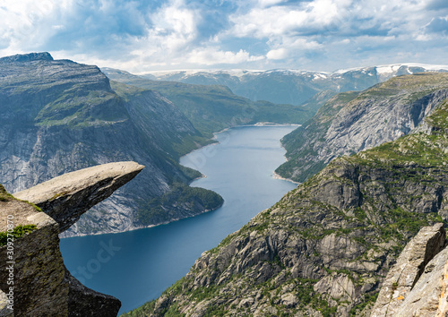 Famous Trolltunga rock over the fjord after an hike in summer in Norway.